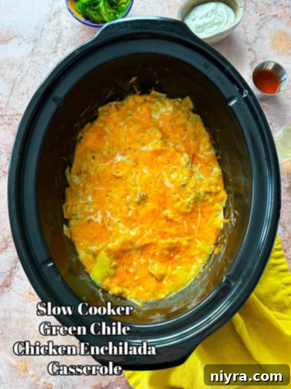 Hero shot of Slow Cooker Green Chile Chicken Enchilada Casserole in a slow cooker, ready to serve
