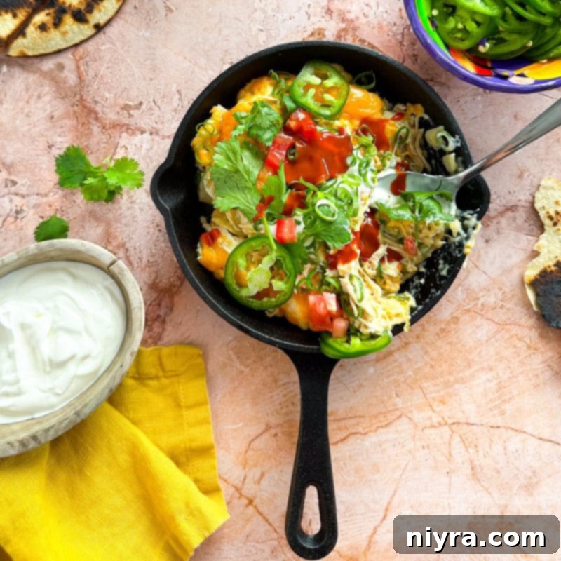 Slow Cooker Green Chile Chicken Enchilada Casserole simmering in a slow cooker