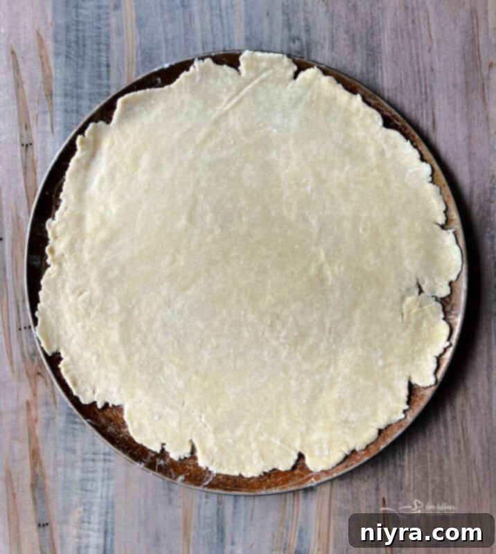 Rustic Apple Tart 7 Dough rolled out on a baking sheet, ready for filling