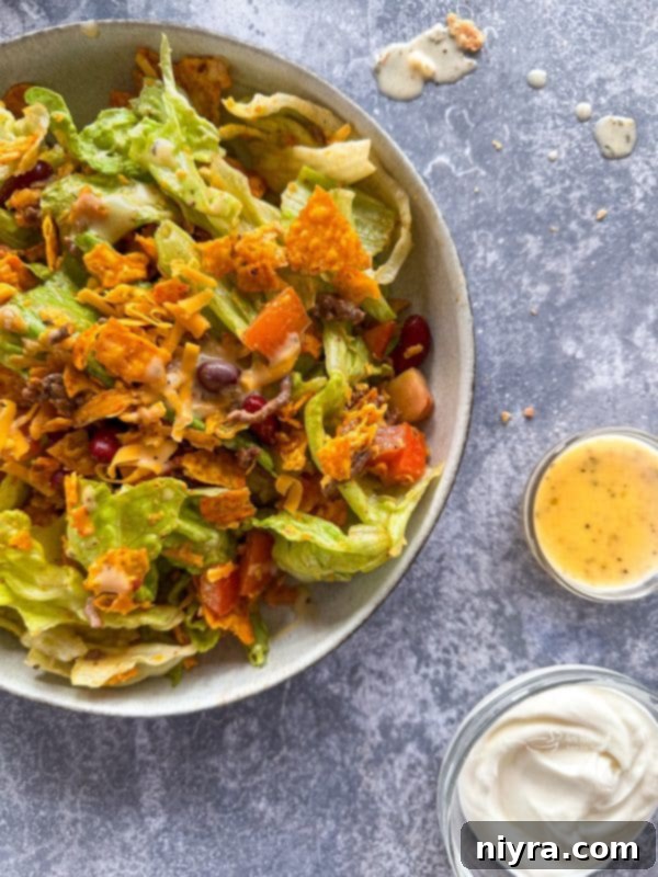 Aunt Sue's Ultimate Doritos Taco Salad 2 Aunt Sue's Doritos Taco Salad served in a large white bowl, garnished with a few whole Doritos chips.