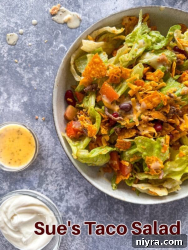 Aunt Sue's Ultimate Doritos Taco Salad 14 A large platter of Doritos Taco Salad with a serving spoon, ready for a party.