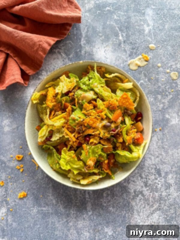 Aunt Sue's Ultimate Doritos Taco Salad 3 A close-up of Doritos Taco Salad ingredients: ground beef, lettuce, tomatoes, cheese, and kidney beans, ready to be mixed.