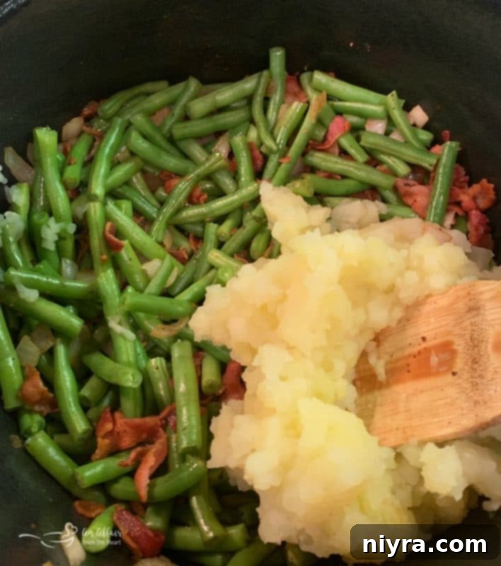 Hearty Bacon, Potato, and Green Bean Soup 5 Potato green bean bacon soup prep showing mashed potatoes being added