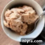 overhead of peanut butter banana ice cream and a spoon in a white bowl.