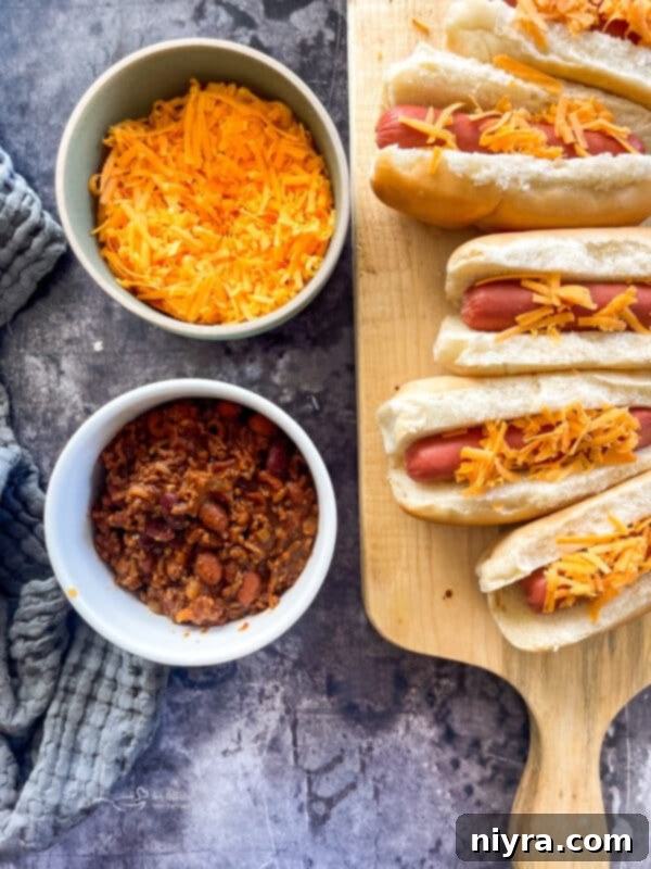 Assembling chili cheese dogs with cheese and chili
