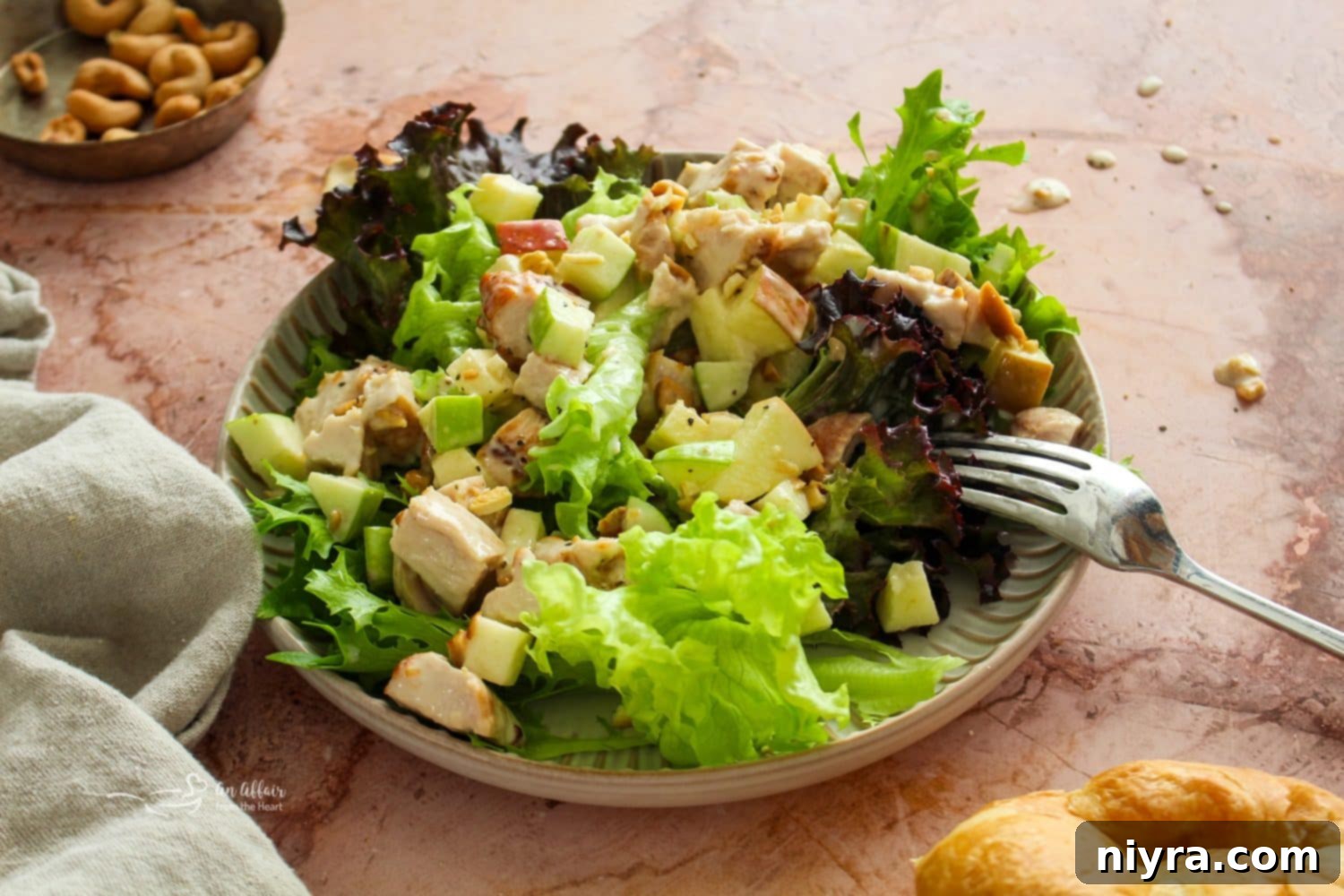 Overhead shot of two delicious Apple Chicken Salad sandwiches on toasted bread, alongside a small bowl of the salad, ready for serving.
