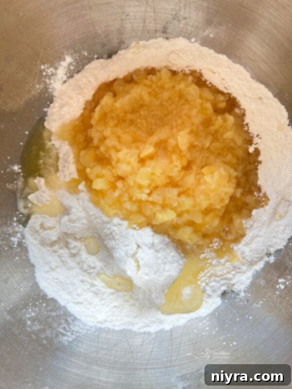 Empty angel food cake mix box and open can of crushed pineapple on a counter
