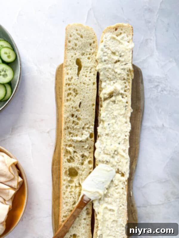 Step 5: Spreading the creamy ranch mixture generously over the baguette halves.