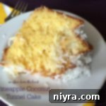 Close up of a slice of Pineapple Coconut Tunnel Cake on a white plate