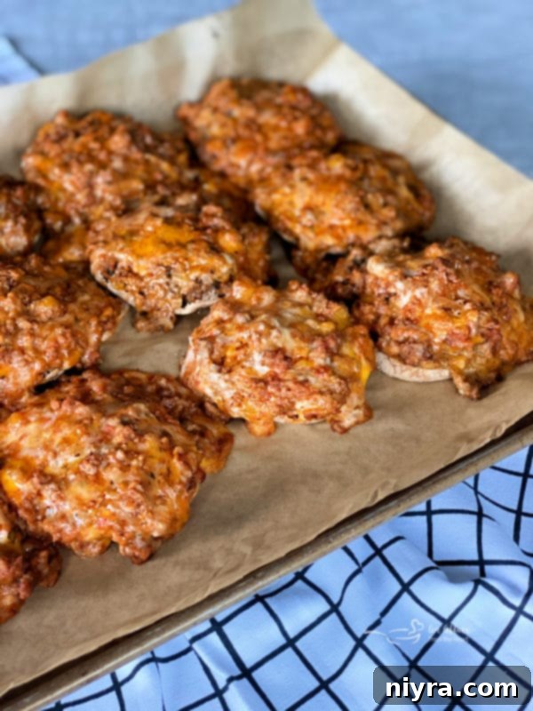 Pizza Burger Melts 7 Assembled Open-Faced Pizza Burgers on English muffins before baking, showing the generous topping