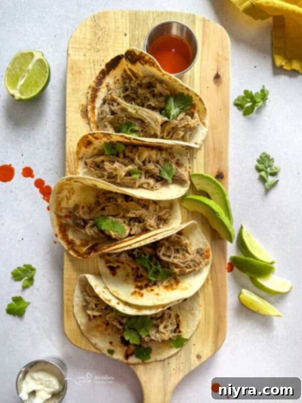 A close-up of slow cooker carnitas tacos with fresh toppings