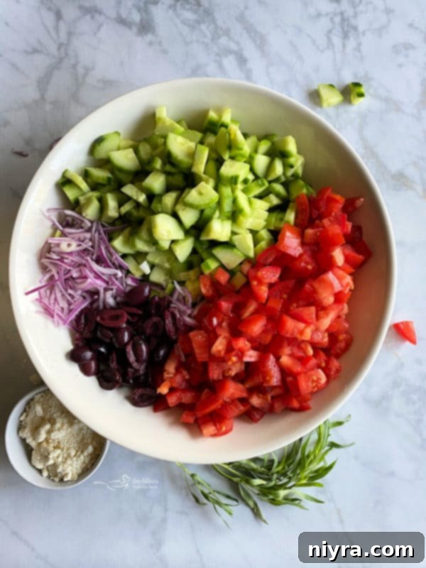 Refreshing Greek Cucumber Salad 3 Tomatoes, olives, cucumbers, and red onion in a white bowl