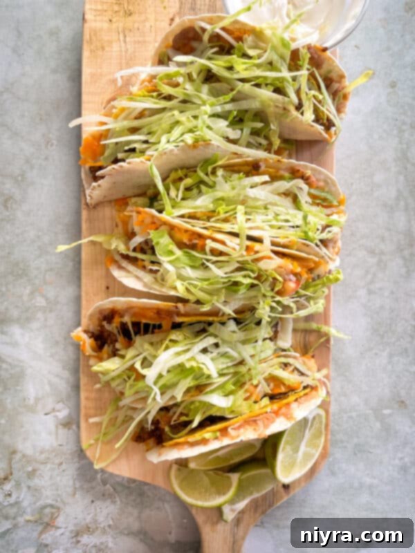 Baked Double Decker Tacos topped with lettuce and tomatoes