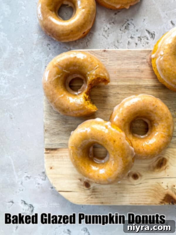 Artistically arranged baked pumpkin donuts with glaze, showcasing their golden-brown exterior and delicious topping