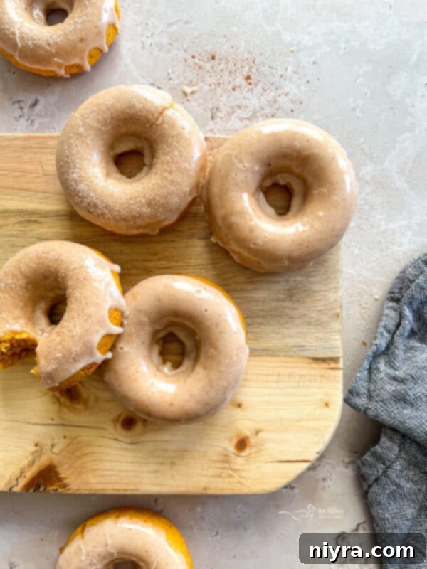 Freshly baked pumpkin donuts cooling on a wire rack before glazing