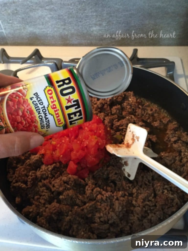 Loaded Tater Tot Taco Bake 6 Browned ground beef in a skillet, seasoned with taco seasoning and ready for RO*TEL and pinto beans.