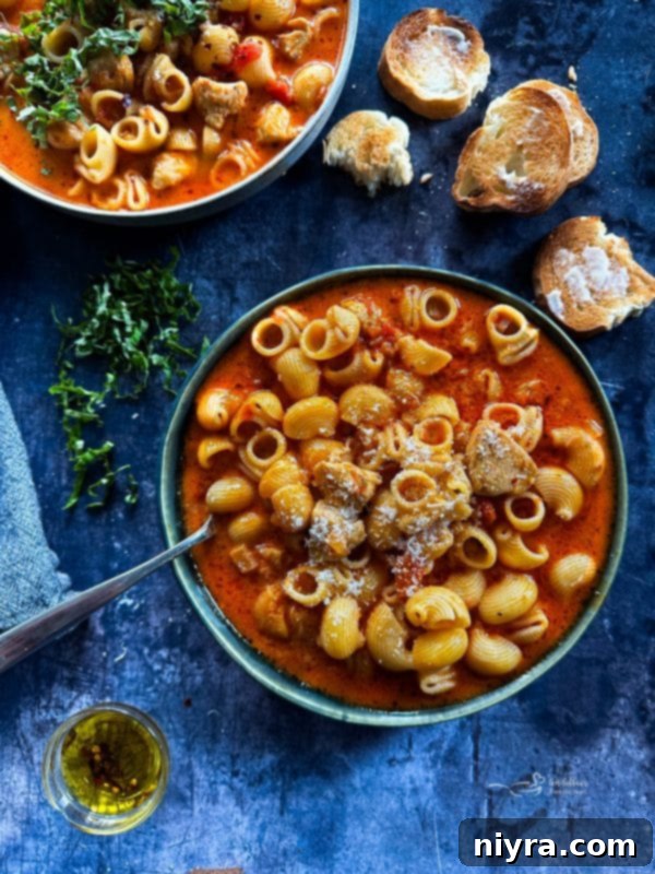A steaming bowl of creamy Chicken Parmesan Soup with fresh herbs