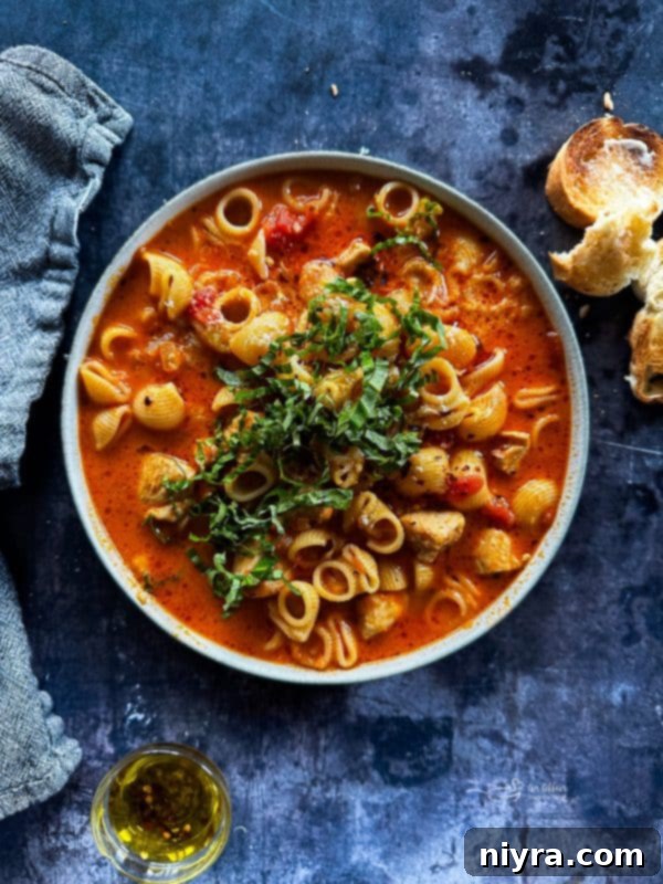 A large pot of creamy Chicken Parmesan Soup with a ladle