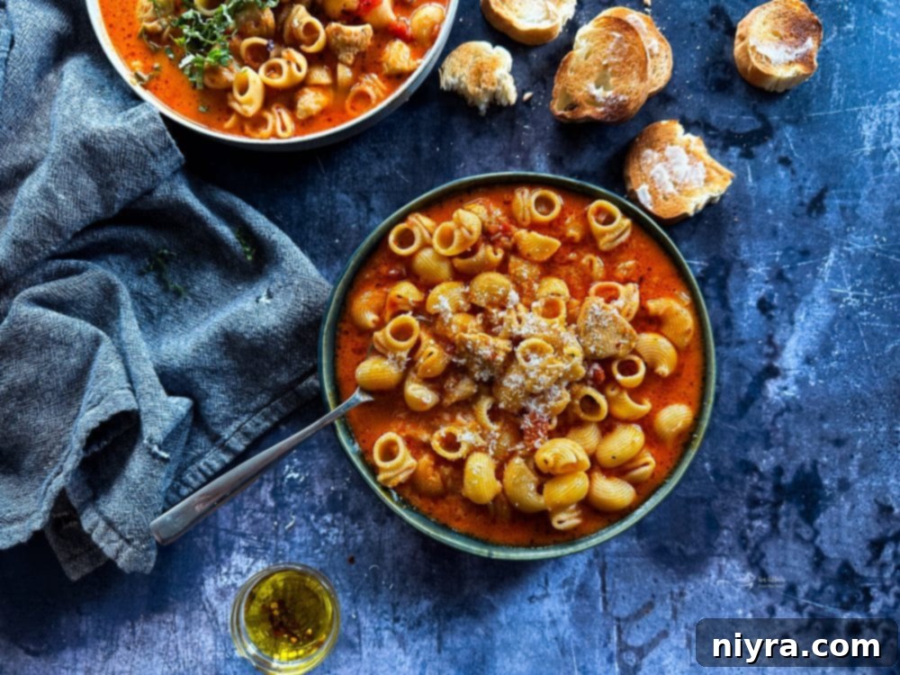 Overhead shot of Chicken Parmesan Soup in a bowl on a wooden surface