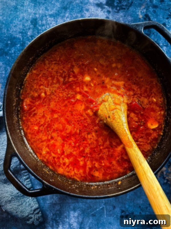 Step-by-step: Adding diced tomatoes, pasta sauce, red pepper flakes, and chicken stock