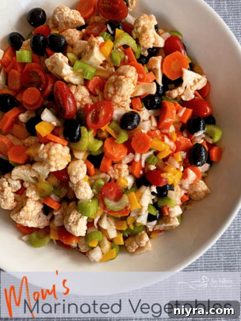 Overhead shot of Mom's Marinated Vegetables in a white bowl, garnished with fresh herbs.