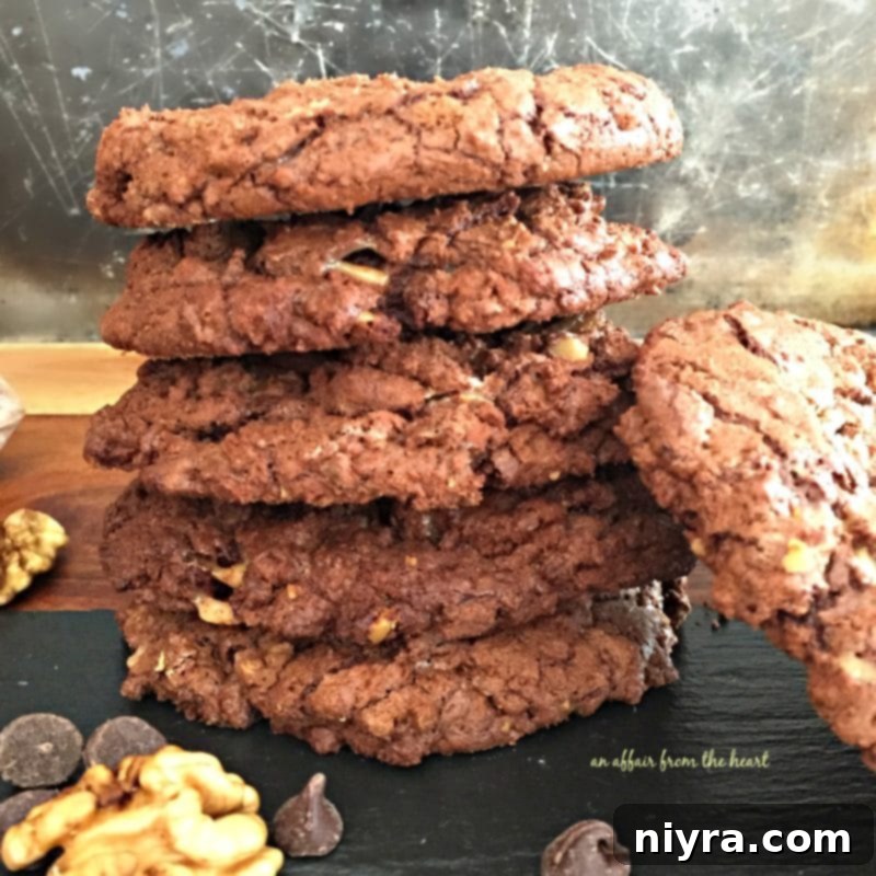 Close up, side view of giant chocolate toffee cookies stacked on a table.