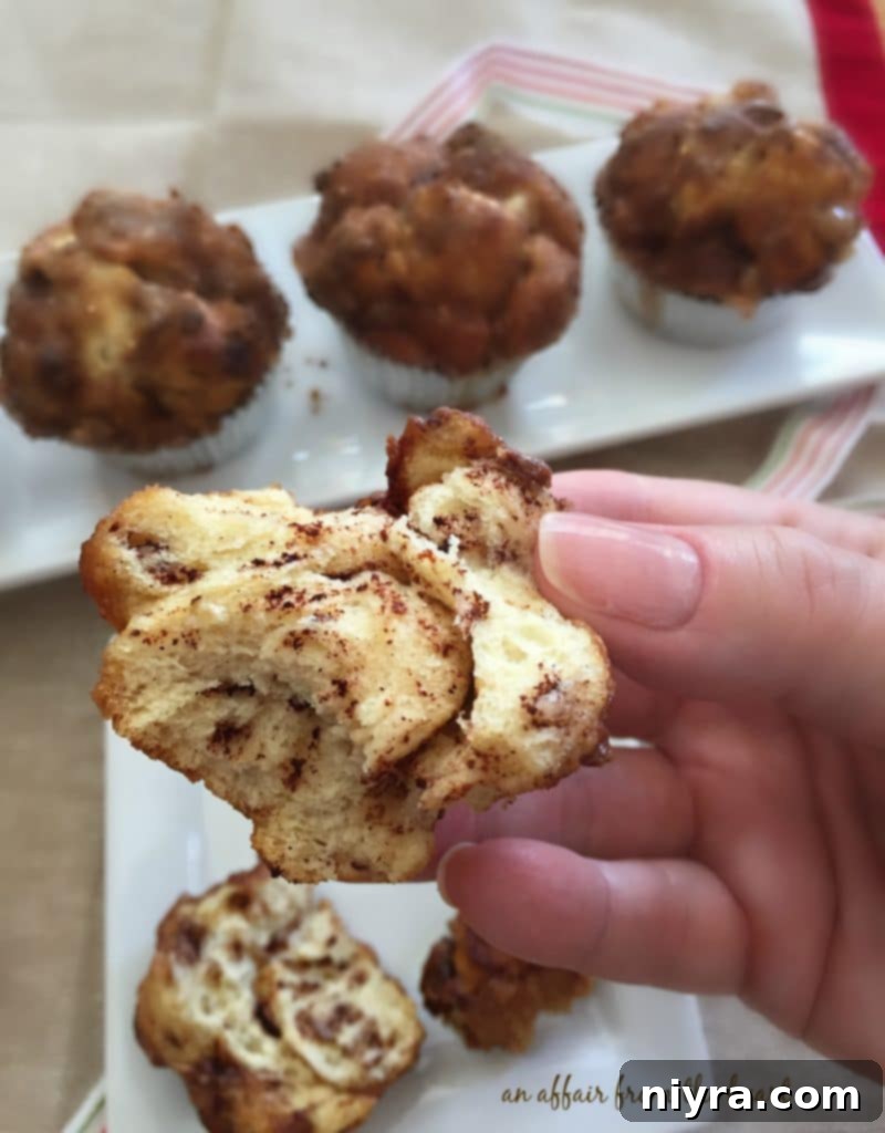 A stack of Cinnamon Toffee Monkey Muffins on a white plate, with a coffee cup in the background.