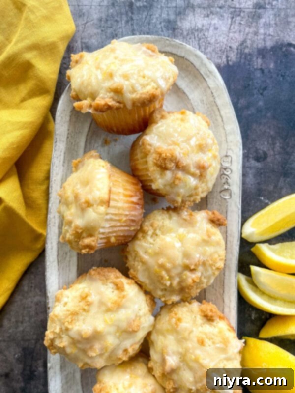 Fluffy and moist bakery-style lemon muffins with a wonderful streusel crumb topping, baked golden brown and glazed with a sweet-tart lemon glaze.