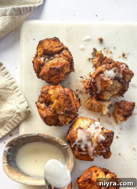 Freshly baked Toffee Monkey Bread Muffins cooling in the muffin tin, with a glossy, caramel-like topping.
