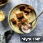 Reuben Chowder 17 Cream of Reuben Soup in a green rimmed pottery bowl with rye croutons and spoonful of soup