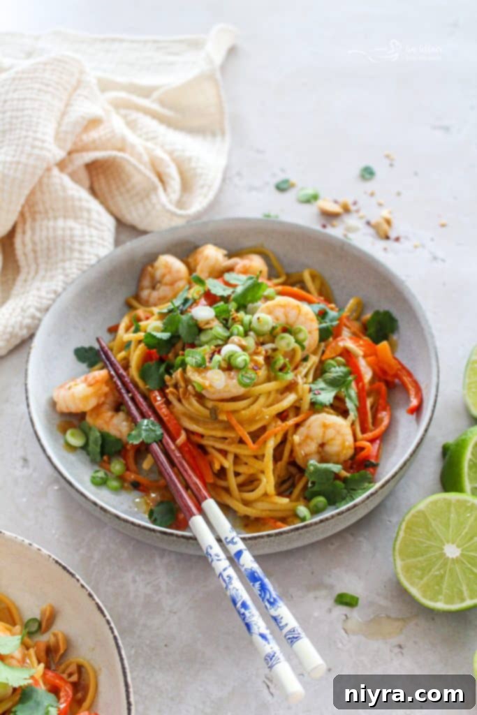 Close-up of One-Pot Pad Thai with shrimp and cilantro in a white bowl.