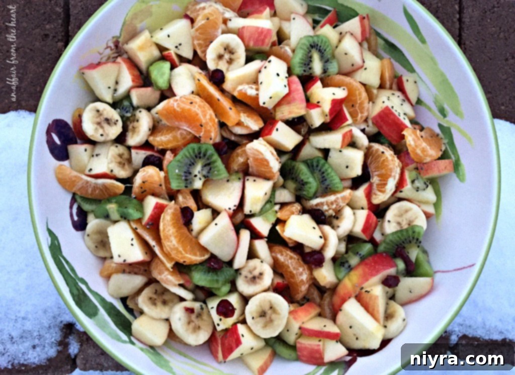 Close-up of vibrant Winter Fruit Salad, showcasing diced apples, kiwis, oranges, and bananas