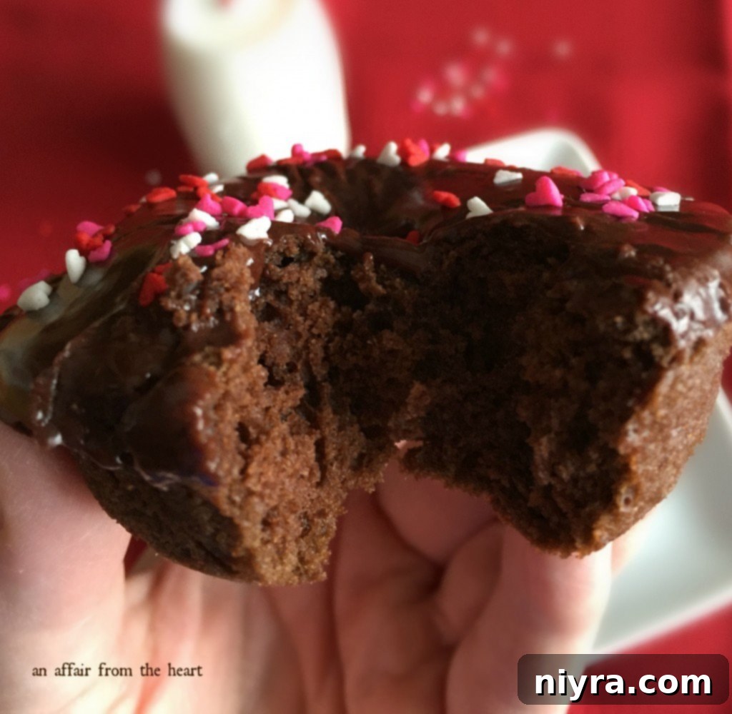 Freshly baked double chocolate donuts cooling on a wire rack with a refreshing glass of milk