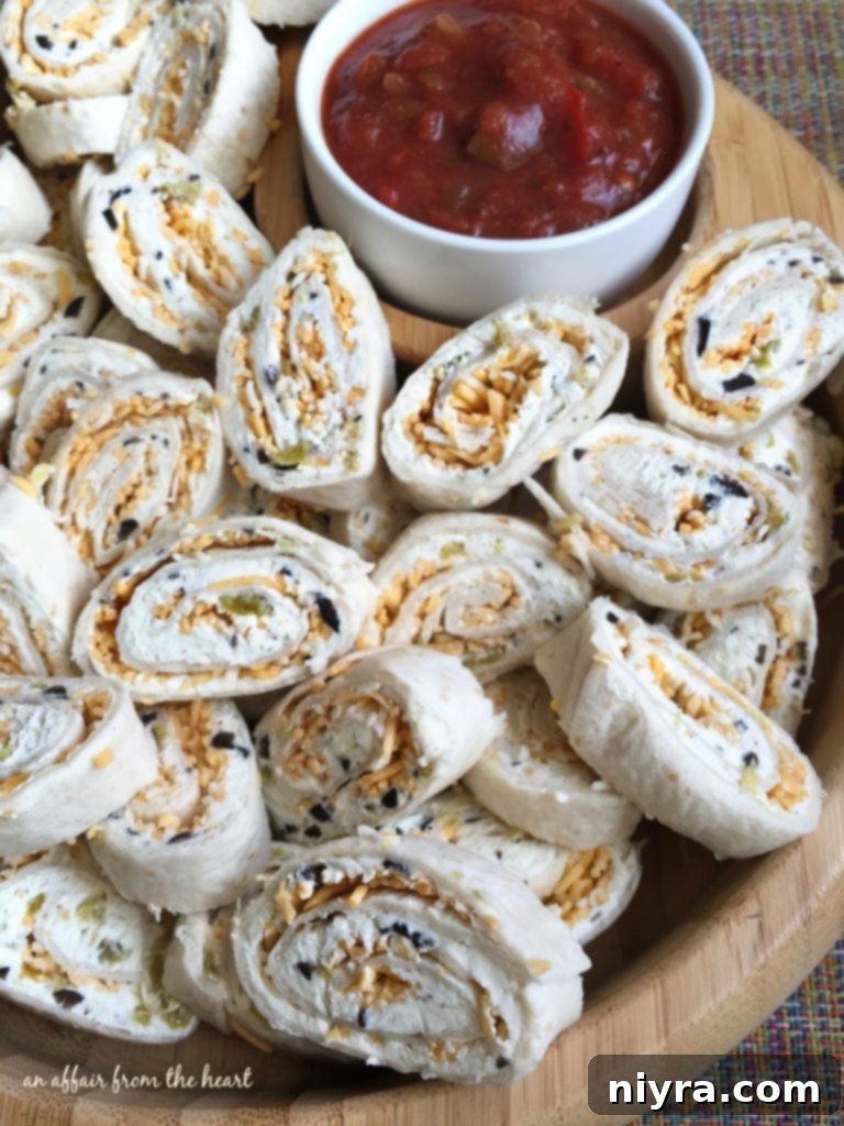 Close-up of freshly sliced Tortilla Pinwheels showing the creamy green chile and olive filling, ready for dipping