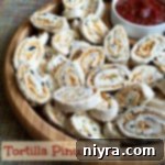 Tortilla Pinwheels on a wooden serving tray with text "tortilla pinwheels" – a perfect appetizer.