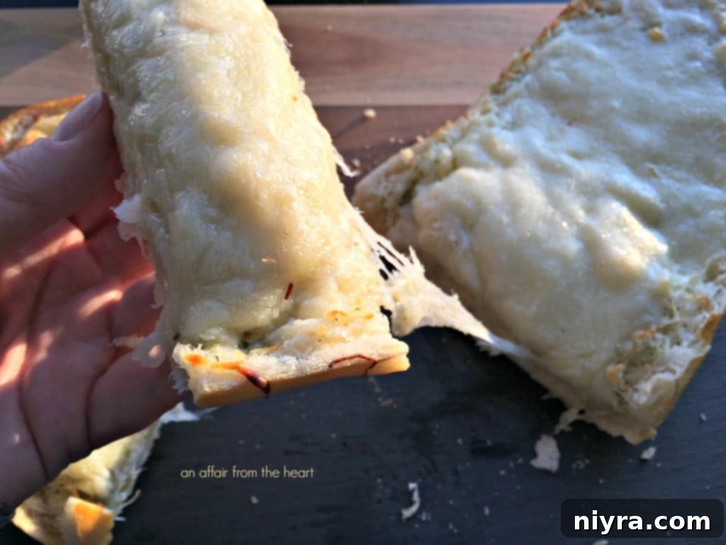 Preparing four cheese roasted garlic bread, showing garlic butter spread on Italian bread