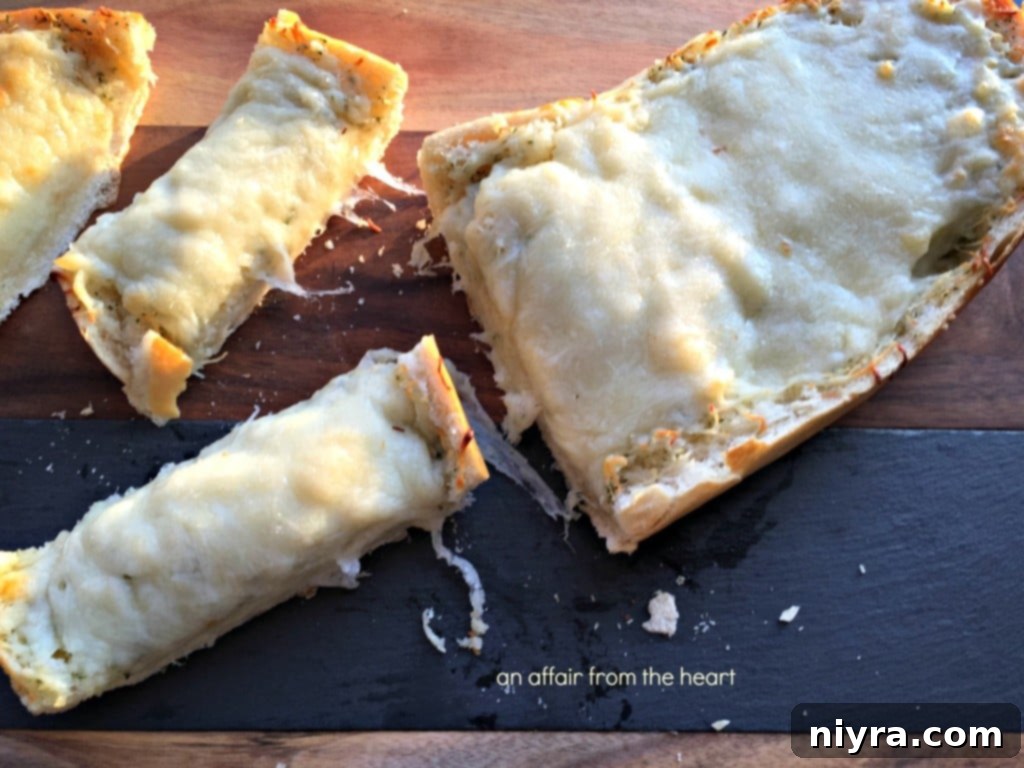 Freshly baked four cheese roasted garlic bread, sliced and ready to eat