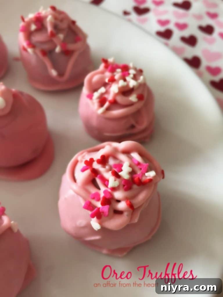 Two hands holding a freshly dipped Oreo Truffle, ready to be decorated