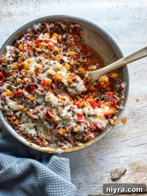 Overhead view of a delicious Stuffed Pepper Skillet, with bell peppers, ground beef, and rice mixture, ready to be cooked.