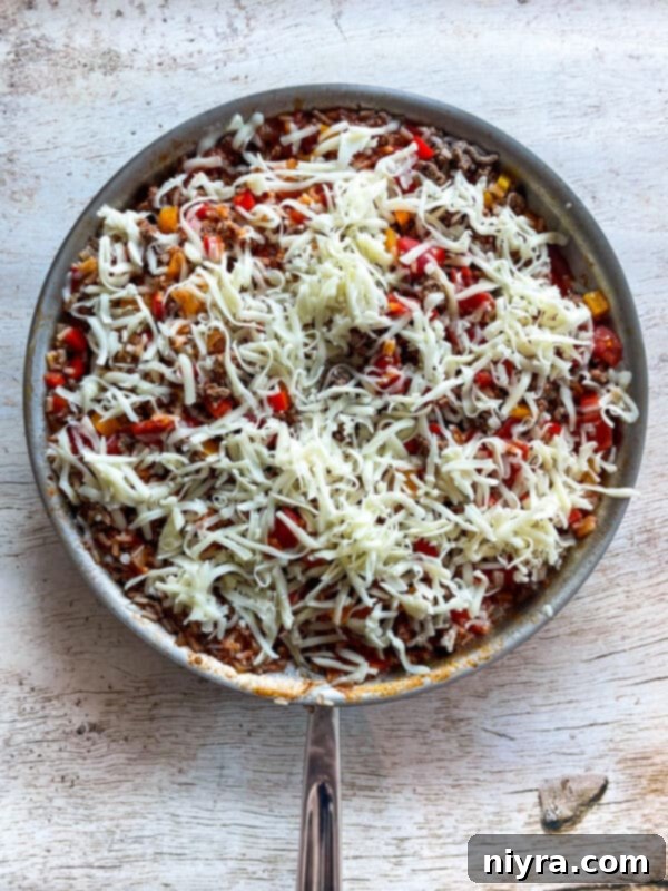 Close-up of Stuffed Pepper Skillet in a pan, with the lid just removed, showing the cooked ingredients before cheese is added.