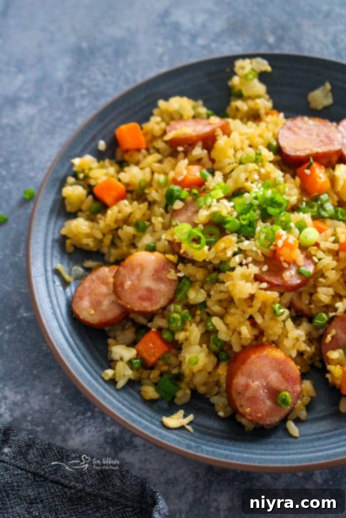 A wider shot of the Kielbasa Fried Rice in a skillet, garnished with green onions.