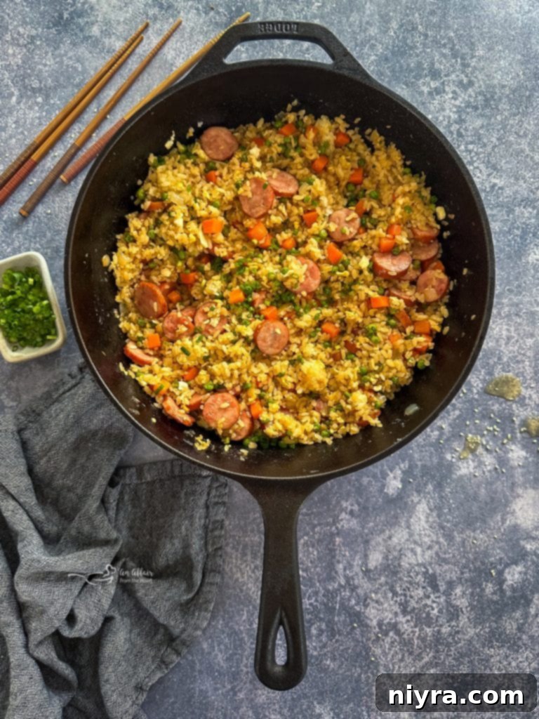 Step 4: Adding day-old sticky rice and soy sauce to the skillet, mixing all ingredients together.