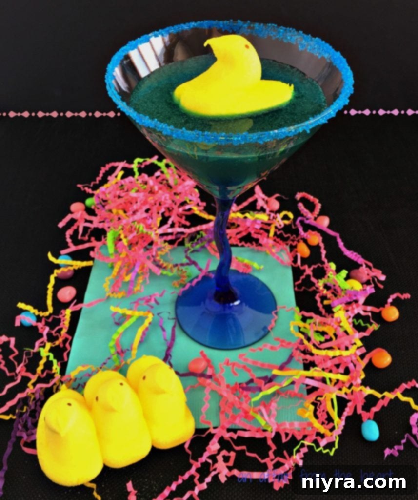 A vibrant blue Peep Tart Martini garnished with a yellow Marshmallow Peep chick, perfect for Easter.