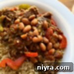 Close up of Crock Pot Spicy Steak & Beans in a white bowl