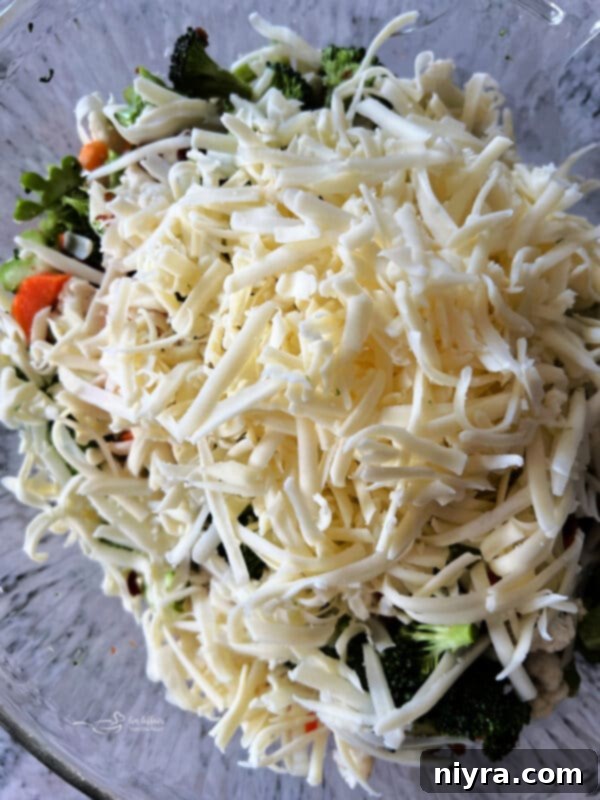 Pegs Fresh Italian Vegetable Salad 9 Shredded mozzarella cheese added to the vegetables and bacon in a bowl