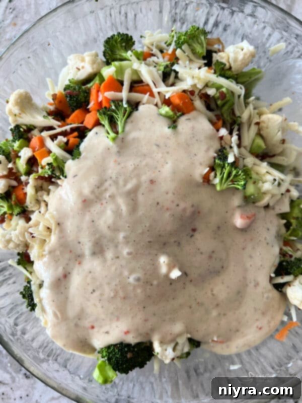 Pegs Fresh Italian Vegetable Salad 10 Creamy Italian dressing being poured over the salad ingredients