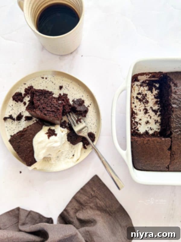 A slice of Depression Cake on a white plate with a fork