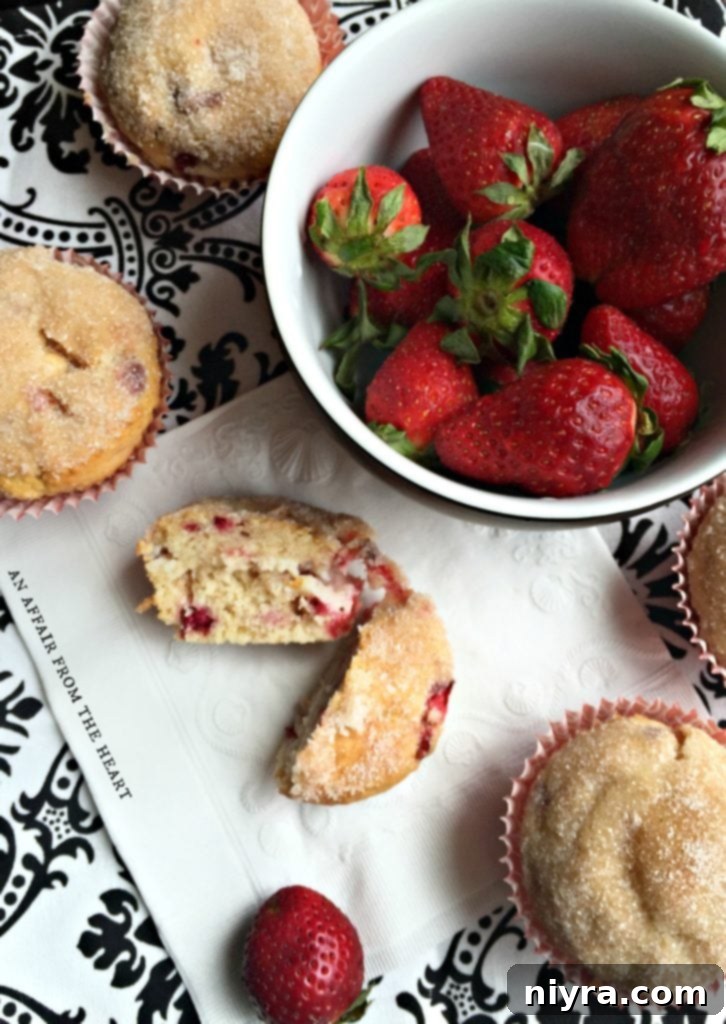 Close-up of freshly baked Strawberry Cheesecake Muffins, topped with cinnamon sugar, on a light background