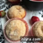 Close-up of a Strawberry Cheesecake Muffin showing the creamy cheesecake center