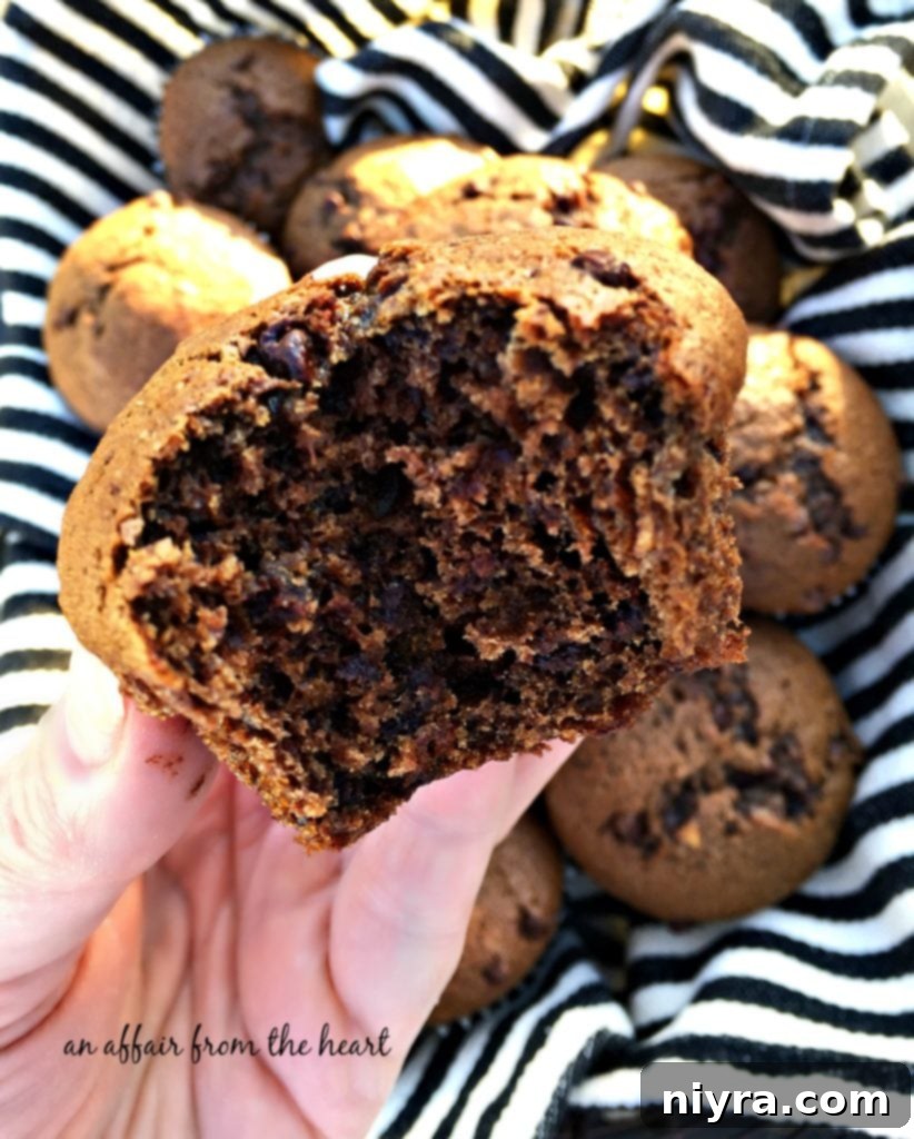 Close-up view of the interior of a double chocolate banana muffin, revealing its moist crumb and generous mini chocolate chips.